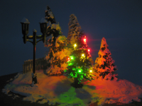Weihnachtsbaum mit Schnee und Lichterkette gelb grün rot...